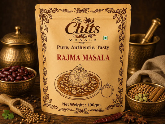 A 100g stand-up pouch of 'The Chits Masala' Rajma Masala, styled on a dark rustic wooden table surrounded by ingredients like red beans, whole spices, and a mortar and pestle.