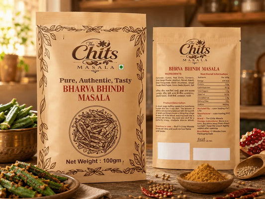 Two stand-up pouches of Chits Masala Bharya Bhindi Masala spice blend displayed on a rustic wooden table with bowls of ingredients like green beans, red chilies, and pomegranate seeds in the background.