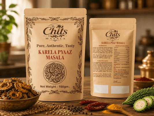 Two stand-up pouches of Chits Masala Karela Pyaar Masala spice blend displayed on a wooden surface with bowls of whole spices, dried pods, and green vegetables in a warm kitchen setting.