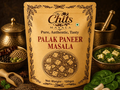 A 100g pouch of The Chits Masala Palak Paneer Masala standing upright on a dark wooden surface, surrounded by cooking ingredients and prepared food in brass bowls.